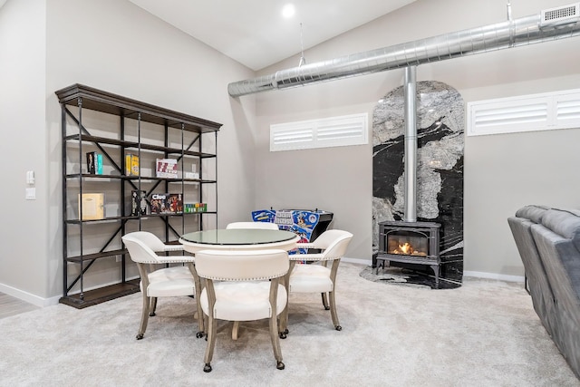 carpeted dining area with lofted ceiling, baseboards, and visible vents