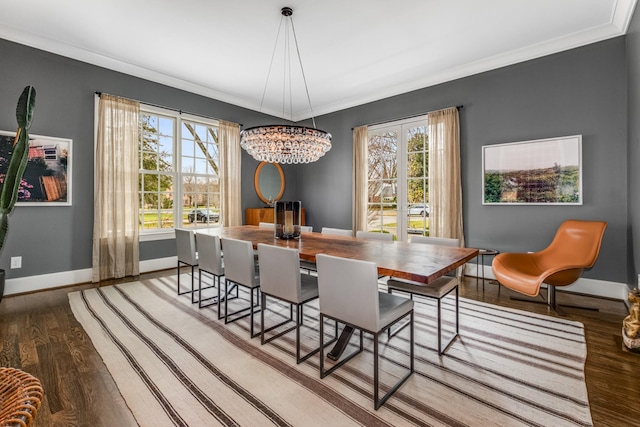 dining space with a wealth of natural light, crown molding, baseboards, and wood finished floors