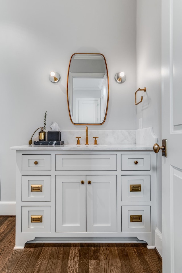 bathroom with vanity, baseboards, and wood finished floors