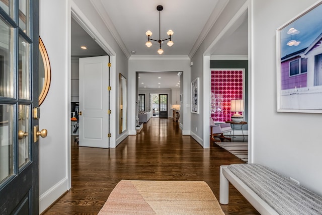 foyer featuring crown molding, baseboards, wood finished floors, and an inviting chandelier