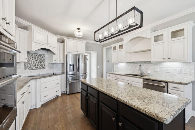 kitchen with a sink, white cabinets, appliances with stainless steel finishes, dark cabinetry, and a center island