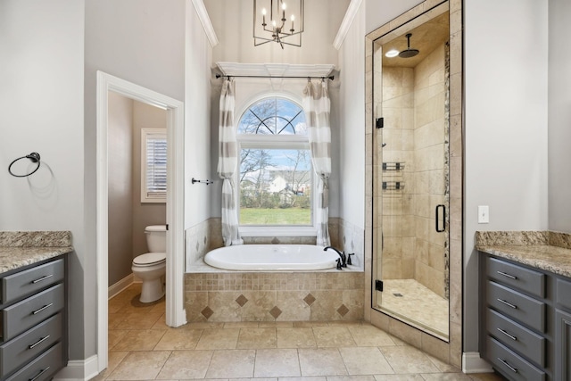 bathroom with toilet, a bath, vanity, a shower stall, and a notable chandelier