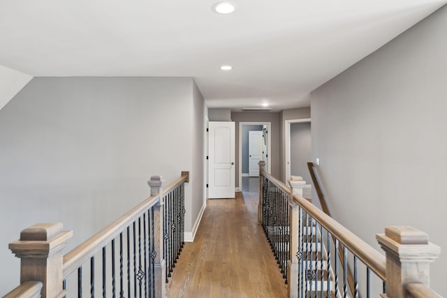 hall featuring recessed lighting, baseboards, an upstairs landing, and wood finished floors