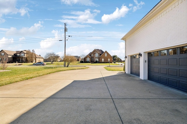 exterior space featuring concrete driveway and a residential view