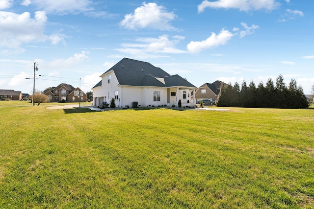 rear view of property with a garage and a lawn