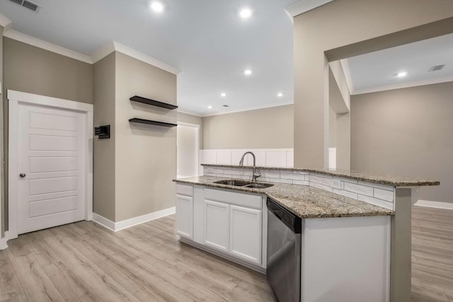 kitchen featuring a sink, light wood-style floors, stainless steel dishwasher, light stone countertops, and crown molding