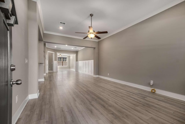 unfurnished living room featuring ornamental molding, ceiling fan, baseboards, and wood finished floors