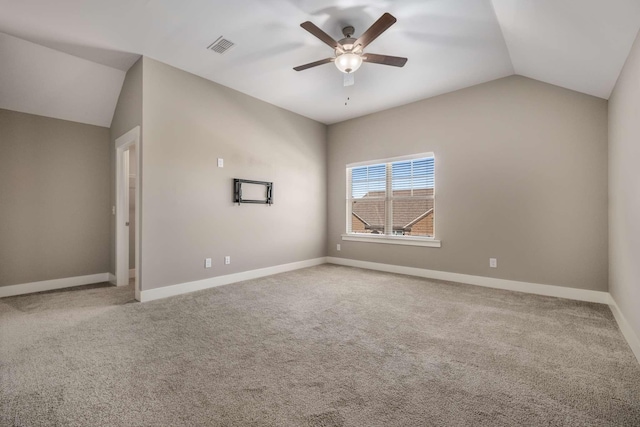 spare room featuring baseboards, visible vents, lofted ceiling, ceiling fan, and carpet floors