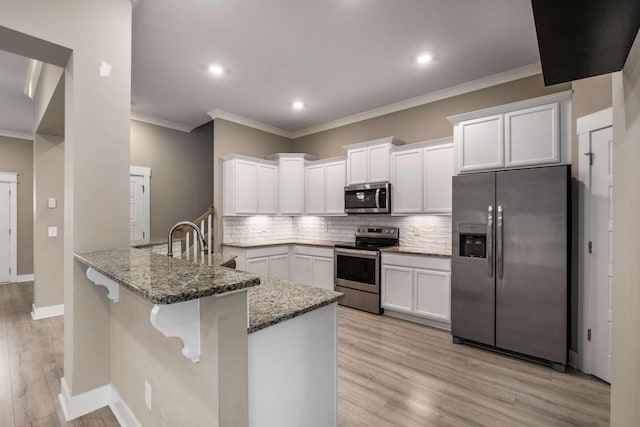 kitchen featuring tasteful backsplash, stone countertops, stainless steel appliances, light wood-style floors, and white cabinetry