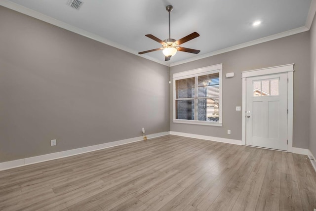 foyer entrance with baseboards, light wood-type flooring, a ceiling fan, and crown molding