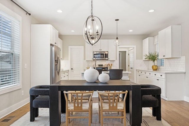 dining area featuring recessed lighting, visible vents, light wood-style flooring, and baseboards