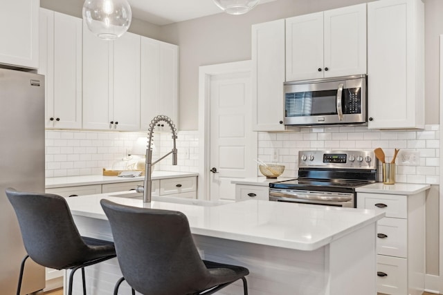 kitchen featuring stainless steel appliances, decorative backsplash, and a kitchen bar