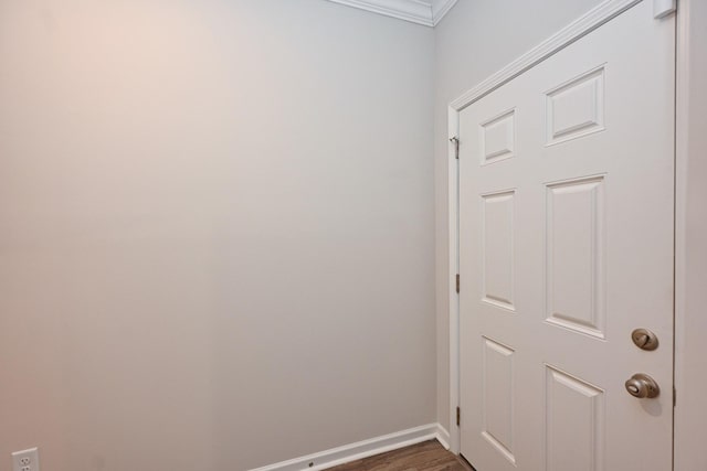 interior space featuring crown molding, dark wood-style flooring, and baseboards