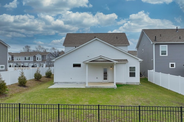 rear view of property with a yard, a patio area, and a fenced backyard