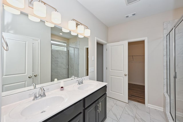 bathroom with a stall shower, visible vents, marble finish floor, a spacious closet, and a sink