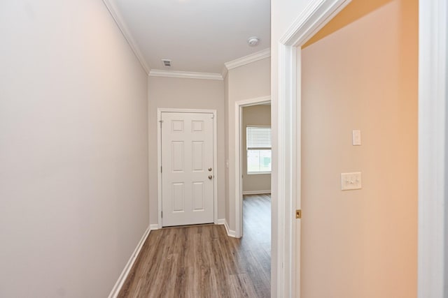 corridor featuring crown molding, baseboards, and wood finished floors