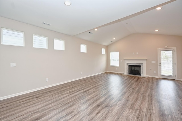 unfurnished living room with a wealth of natural light, wood finished floors, and visible vents