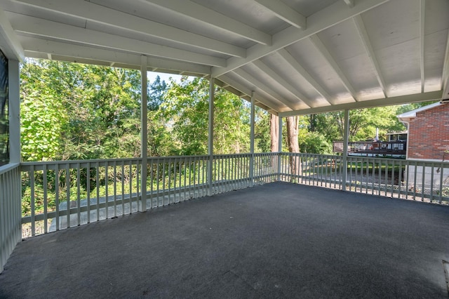 unfurnished sunroom featuring lofted ceiling with beams