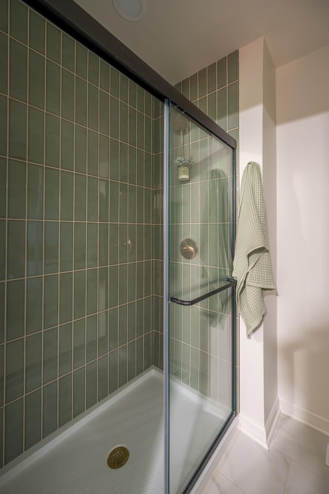 full bathroom featuring a stall shower, tile patterned floors, and baseboards