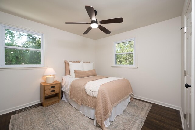 bedroom featuring baseboards, visible vents, ceiling fan, and wood finished floors