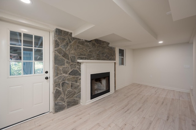 unfurnished living room featuring a large fireplace, recessed lighting, wood finished floors, and baseboards