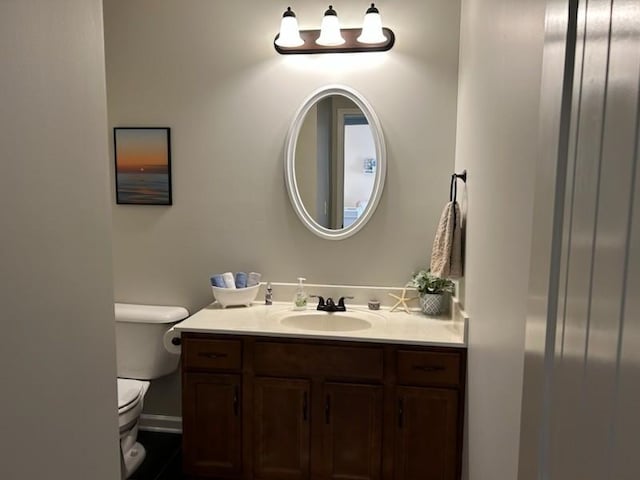 half bath featuring vanity and toilet