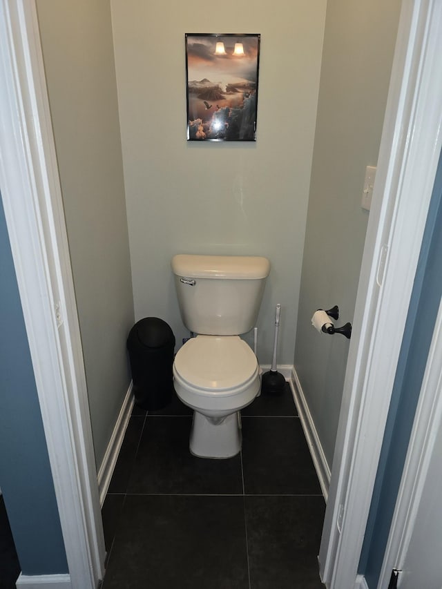 bathroom featuring tile patterned flooring, baseboards, and toilet