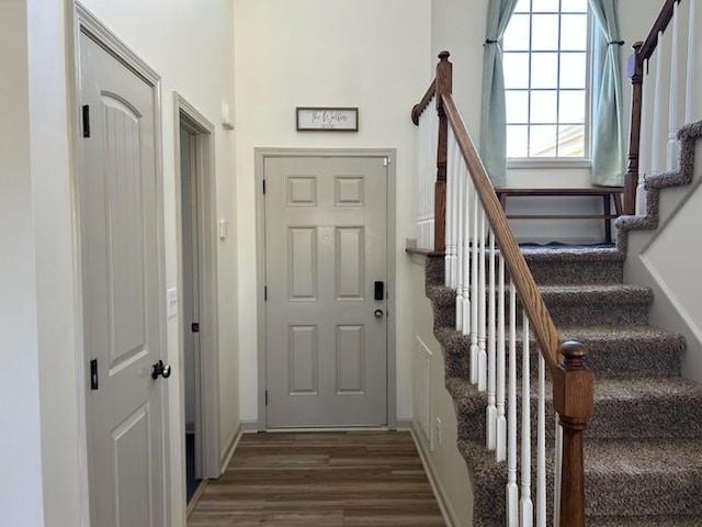 foyer featuring dark wood-style flooring and stairway