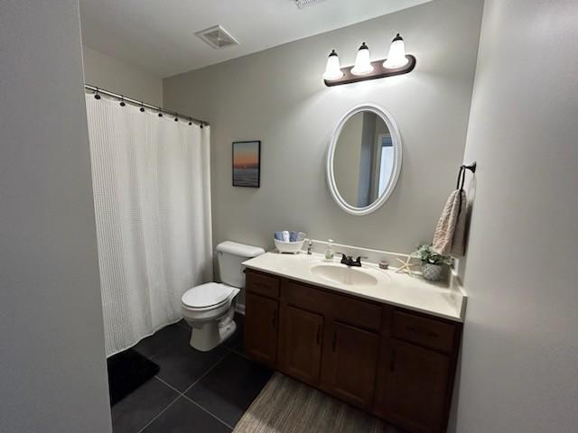 full bath with tile patterned flooring, visible vents, vanity, and toilet