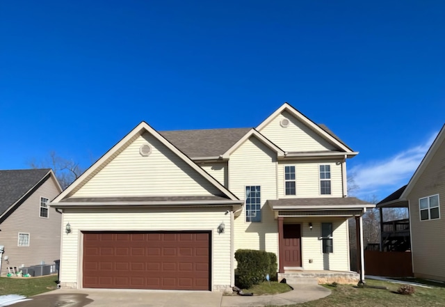 traditional-style house featuring driveway, an attached garage, and cooling unit