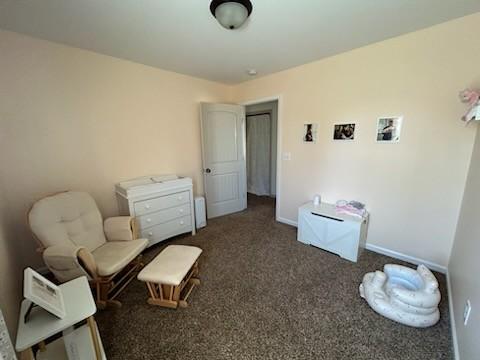 sitting room featuring carpet and baseboards