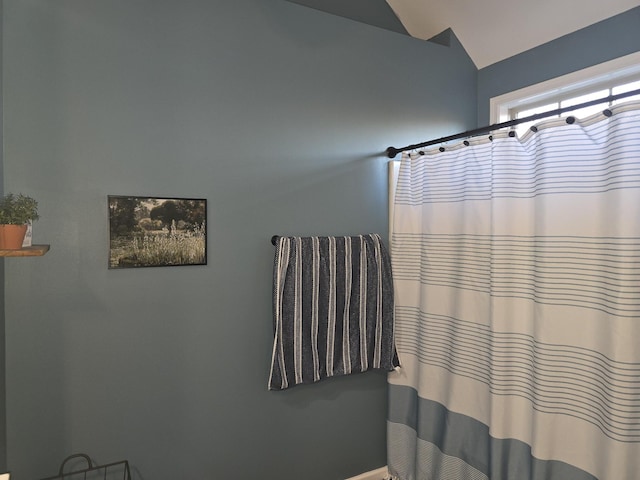 full bath with lofted ceiling and a shower with shower curtain