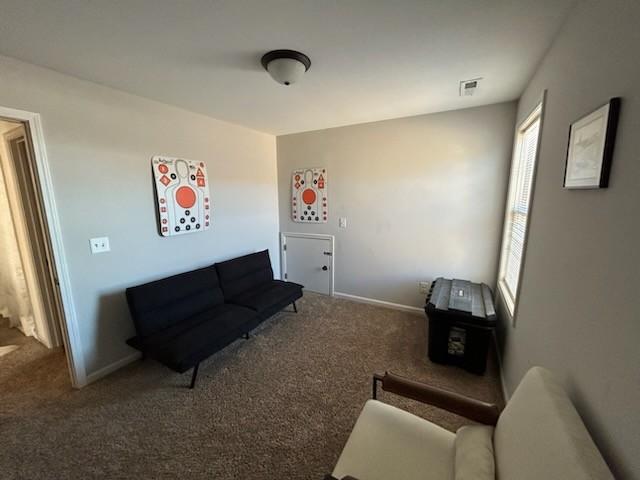 carpeted living room with visible vents and baseboards