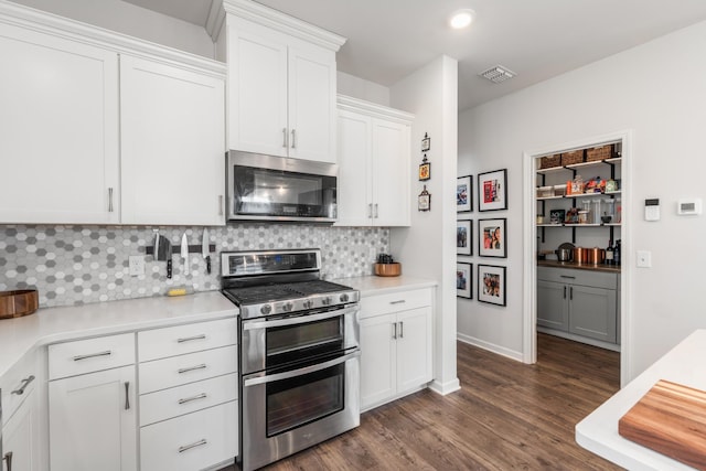 kitchen with light countertops, appliances with stainless steel finishes, white cabinetry, and tasteful backsplash