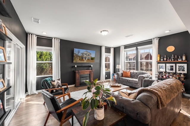 living area featuring plenty of natural light, visible vents, and wood finished floors