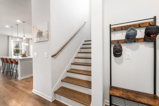 stairs featuring wood finished floors and baseboards