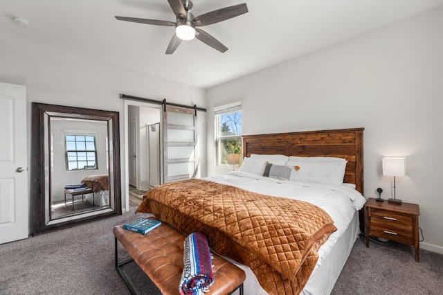 carpeted bedroom featuring ceiling fan and a barn door