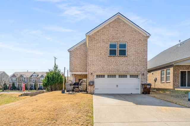 traditional home featuring a front lawn, concrete driveway, brick siding, and an attached garage