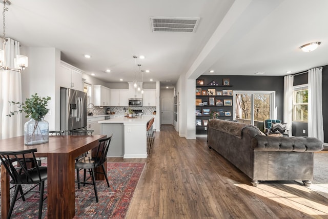 dining space featuring baseboards, visible vents, dark wood finished floors, and recessed lighting