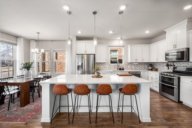 kitchen featuring stainless steel appliances, a center island, a sink, and a kitchen breakfast bar