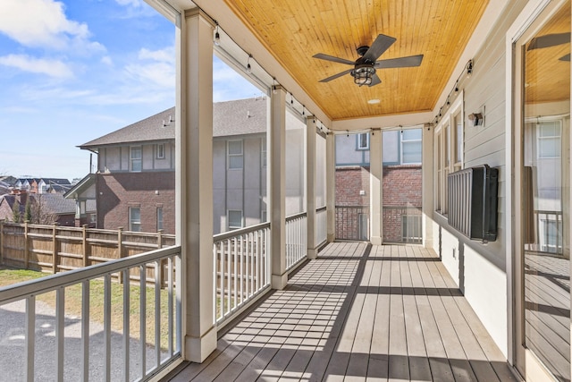 wooden terrace featuring a residential view and a ceiling fan