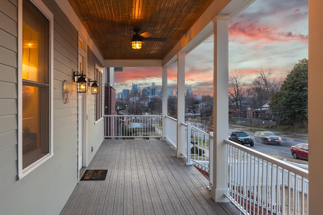 deck at dusk featuring ceiling fan