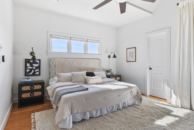 bedroom with a ceiling fan, baseboards, and wood finished floors