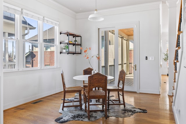 dining space with baseboards, visible vents, and wood finished floors