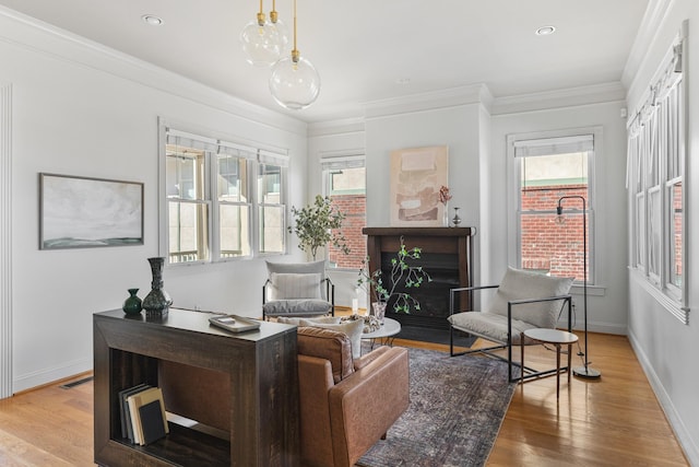 sitting room with ornamental molding, baseboards, and wood finished floors