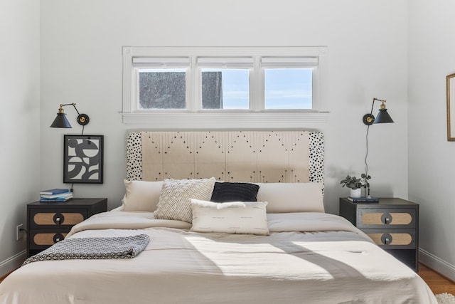 bedroom with baseboards and wood finished floors