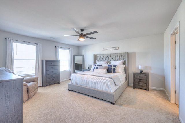 carpeted bedroom with visible vents, baseboards, and a ceiling fan