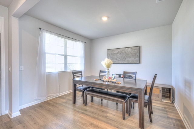 dining area with light wood-style floors and baseboards