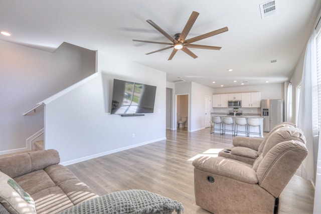 living area with baseboards, visible vents, ceiling fan, light wood-type flooring, and recessed lighting