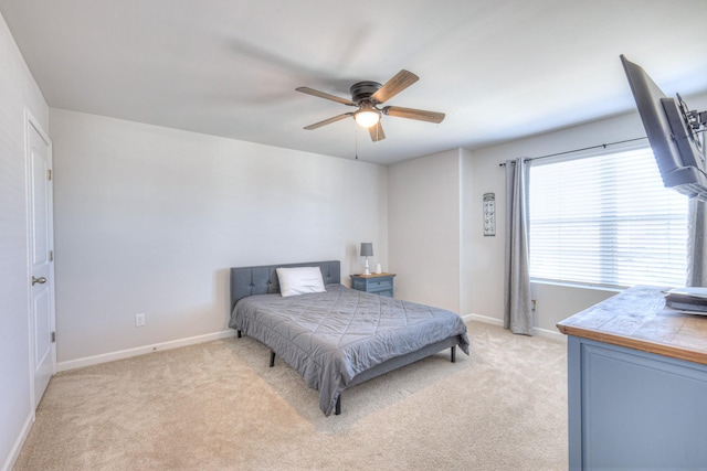 bedroom with a ceiling fan, light colored carpet, and baseboards